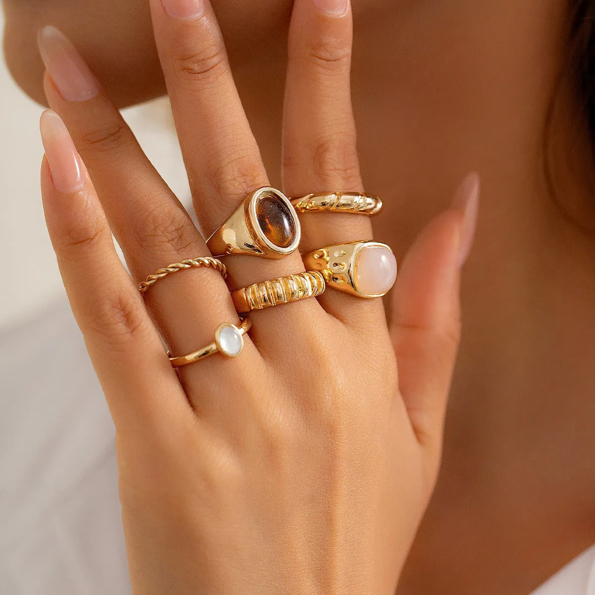 Six geometric light gold alloy rings arranged in set with electroplated finish