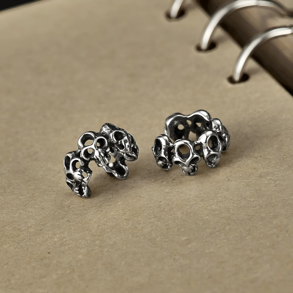 Stainless steel skull earrings with geometric hollow design and clip fitting in metallic finish