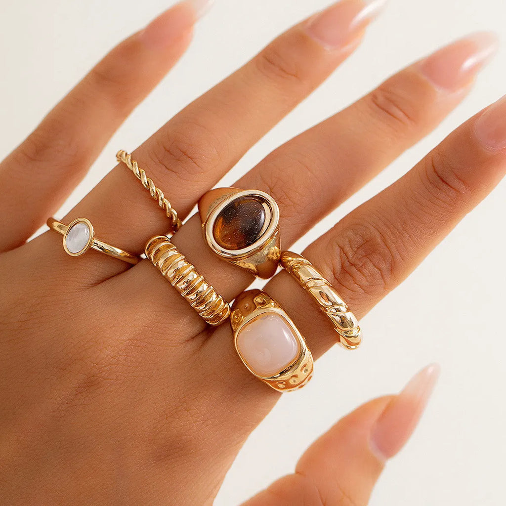 Six geometric light gold alloy rings arranged in set with electroplated finish