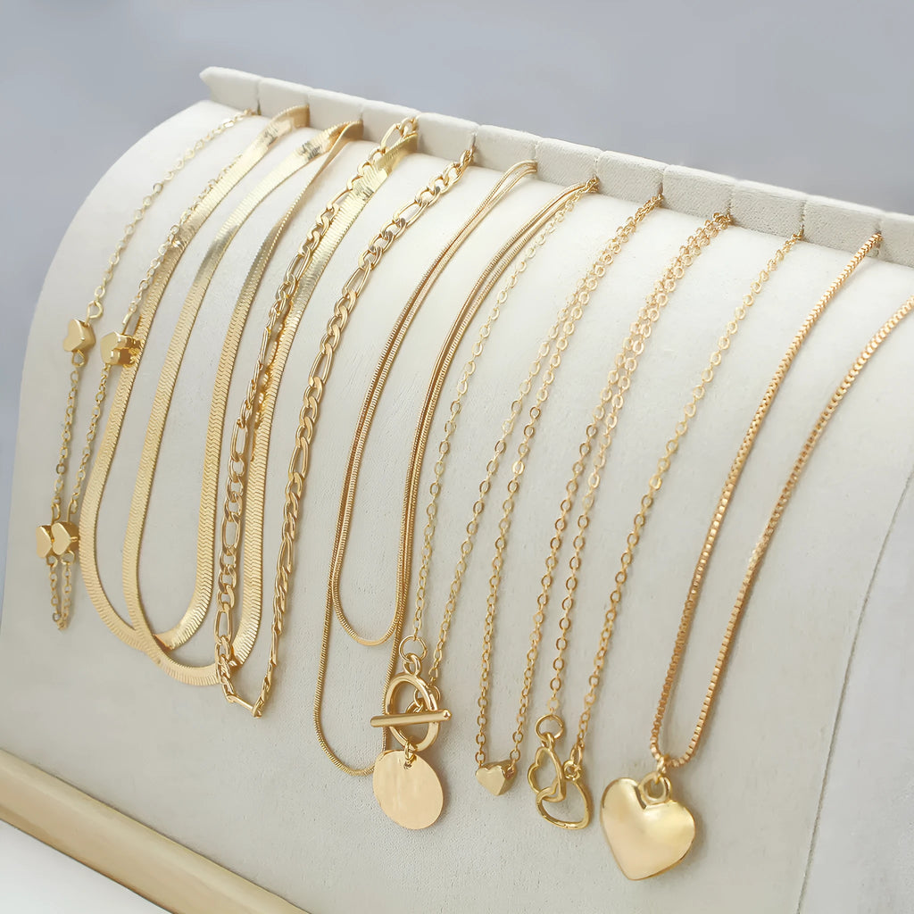 Ten gold necklaces with alloy pendants on adjustable snake bone chains in a women's jewellery set