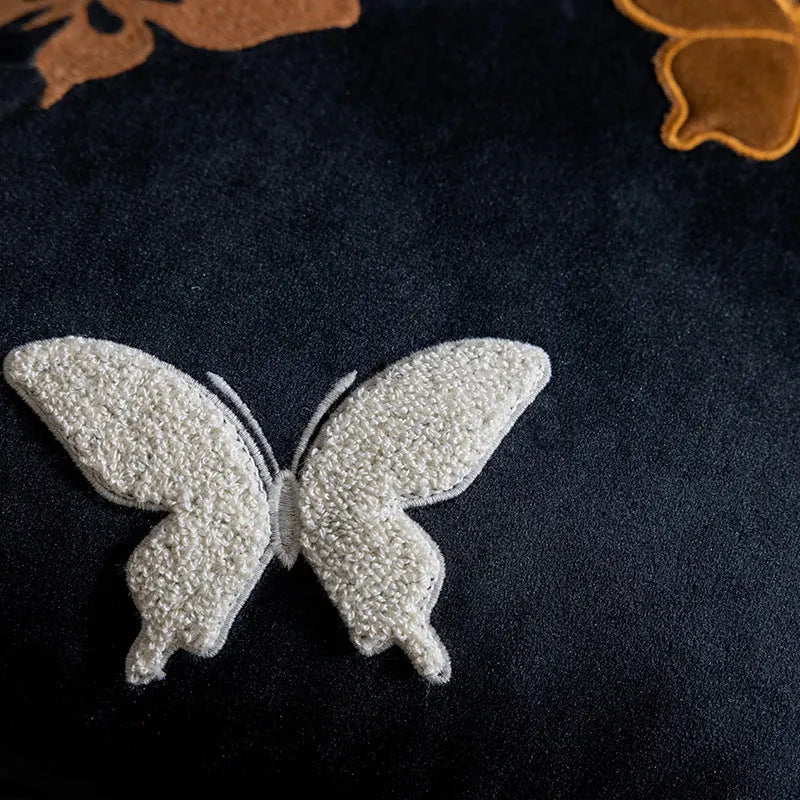 Square beige cushion with detailed black butterfly embroidery in a Chinese style pattern.