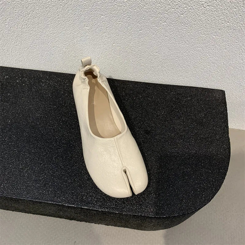 Women's black chunky low heel pumps with round toe and split toe horseshoe design on a rubber sole.