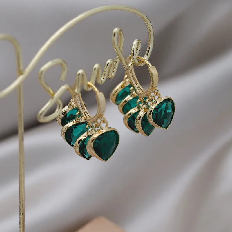 Pair of green heart-shaped pendant ear clips on a copper clip with Korean style design.