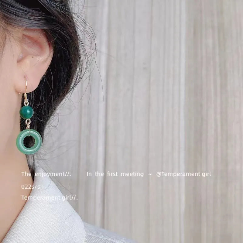 A pair of geometric green jade design Peace Buckle earrings in zinc alloy on a white background.