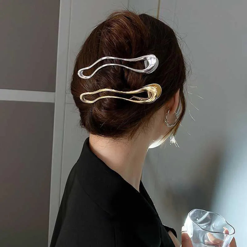 Golden zinc alloy hair barrette in an arc shape on a white background