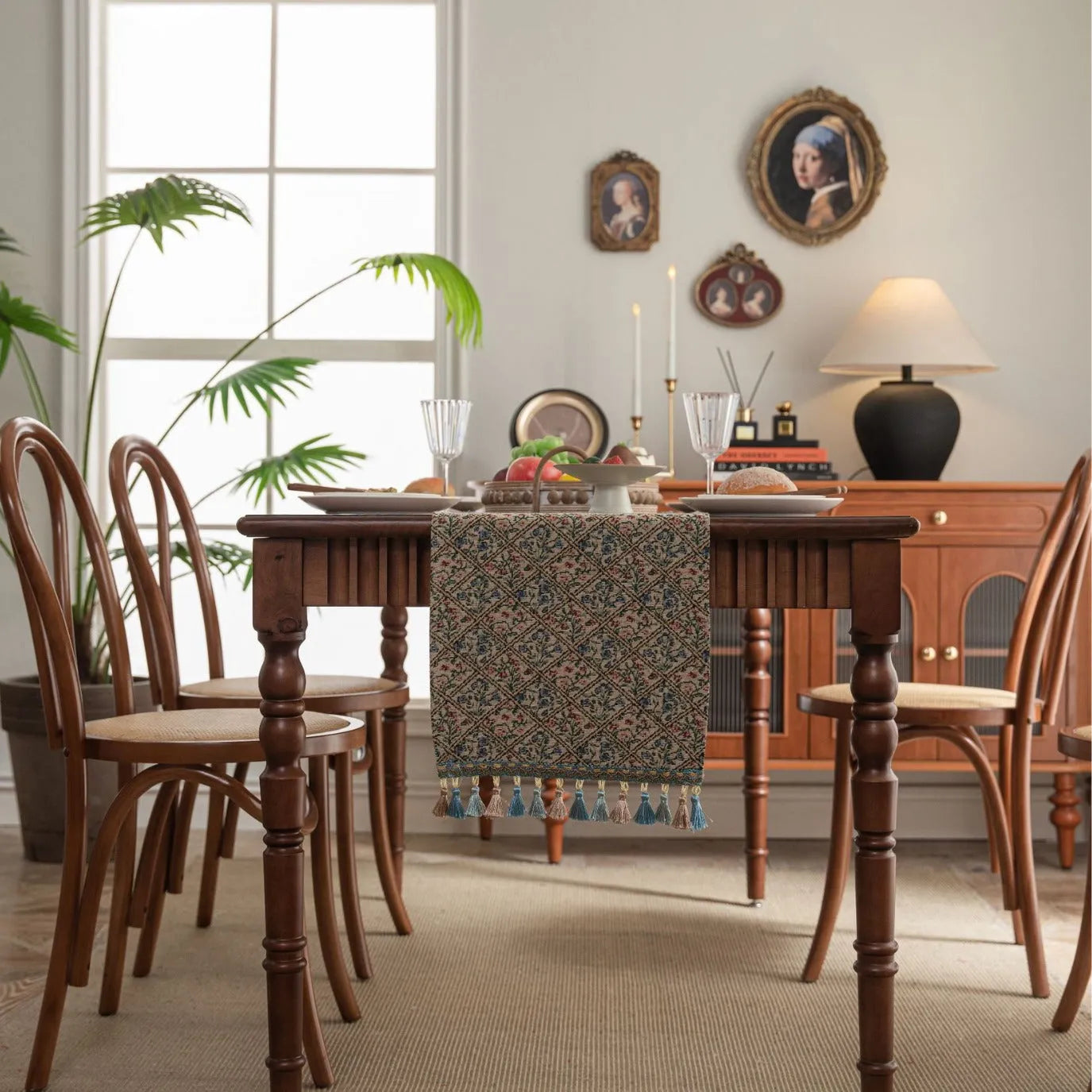 Dark blue and white striped jacquard table runner with tassel trim laid on a wooden dining table.