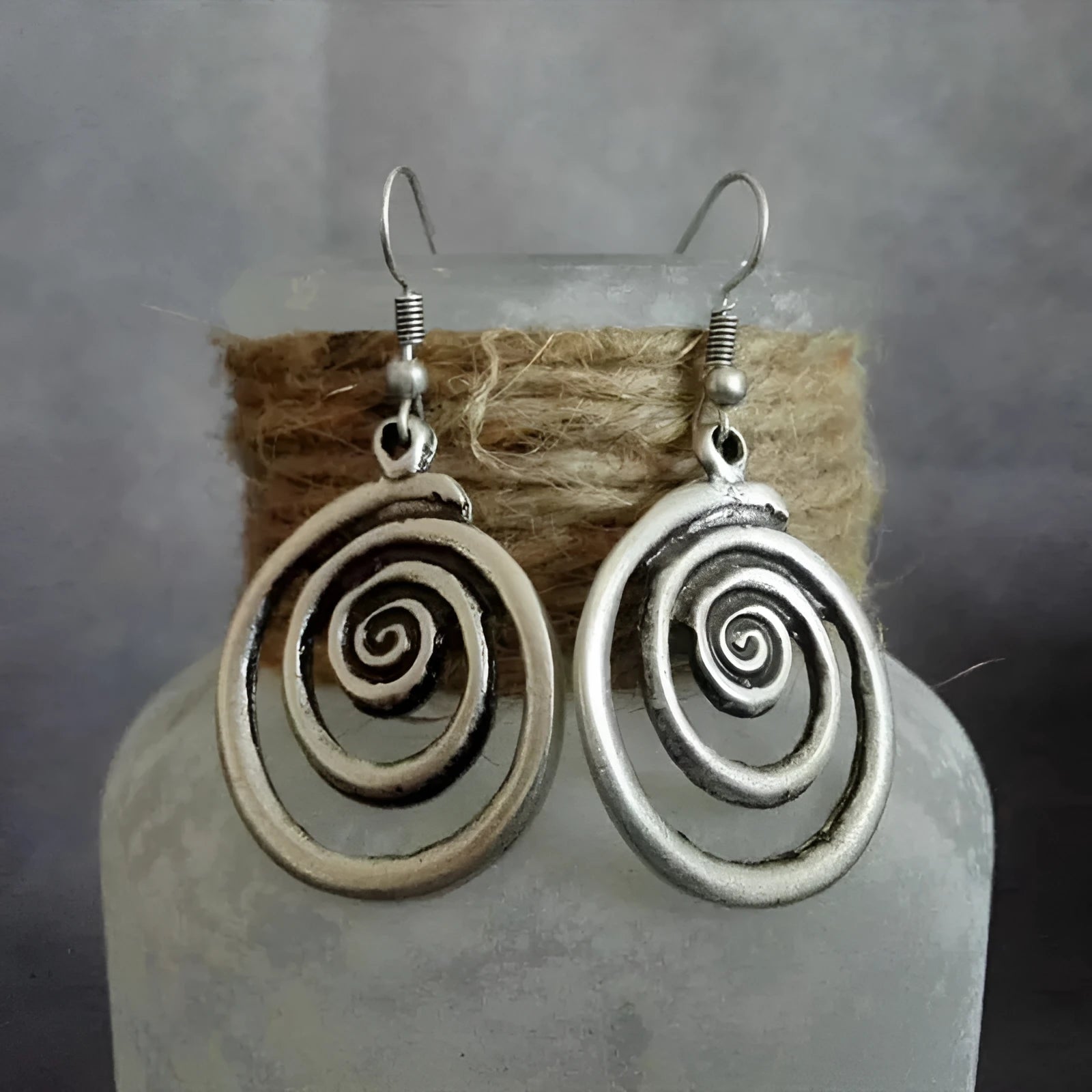 Geometric spiral distressed silver earrings measuring 2.6cm by 5cm with unisex design