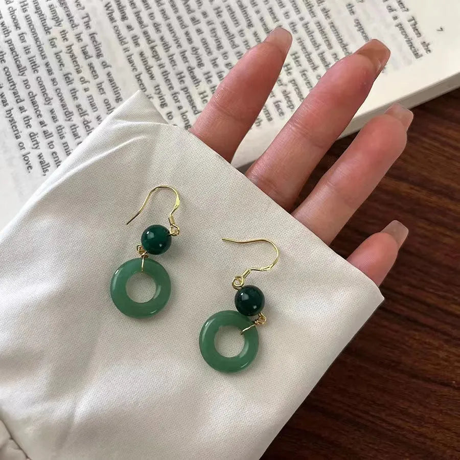 A pair of geometric green jade design Peace Buckle earrings in zinc alloy on a white background.