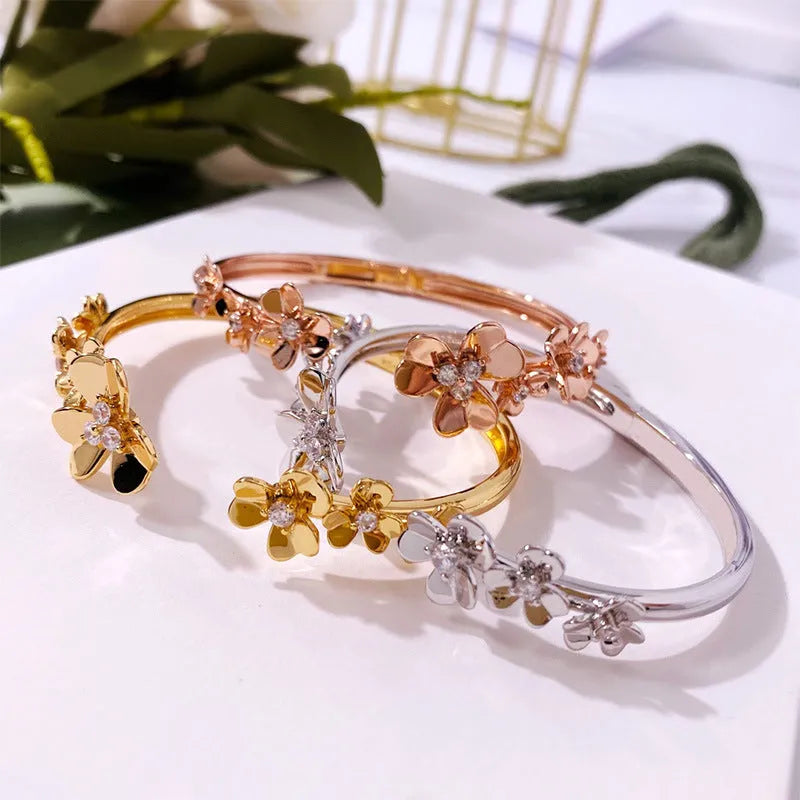 Three-leaf flower micro inlaid zircon bracelet in gold, rose gold, and silver colours on a copper base with electroplated finish.