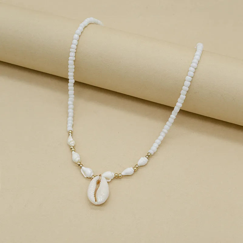 White conch shell pendant necklace on a regular chain, made from mother pearl shellfish.