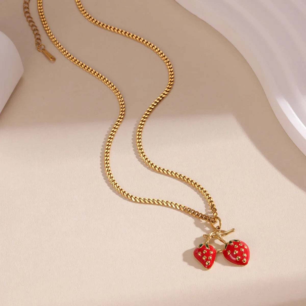 Stainless steel strawberry fruit pendant necklace on an alloy chain, shown in red and white colour options.