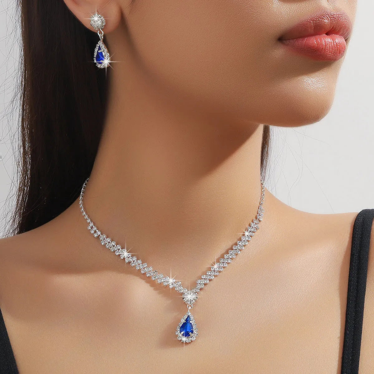 Claw chain necklace and matching earrings set with drop-shaped rhinestones in multiple colour options