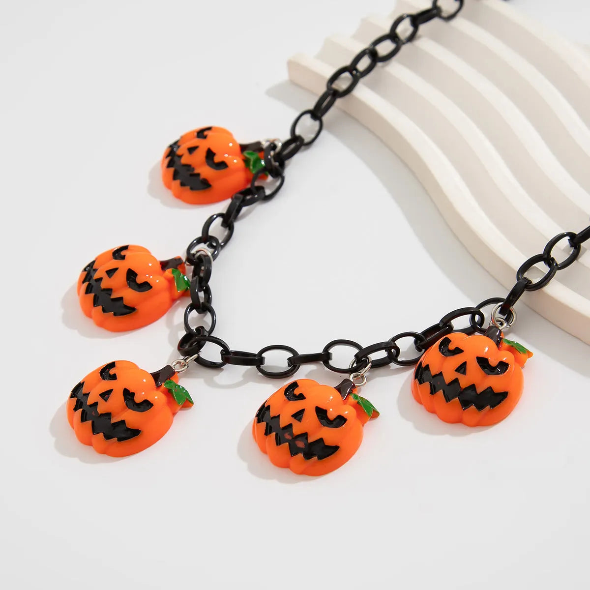 Halloween necklace with ghost and pumpkin cartoon pendants on a chain, in mixed colours.