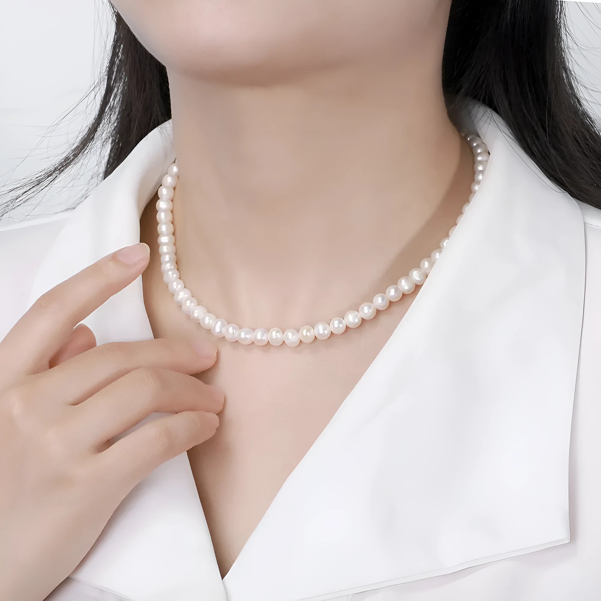 Women's adjustable silver necklace with natural freshwater pearls on a model.