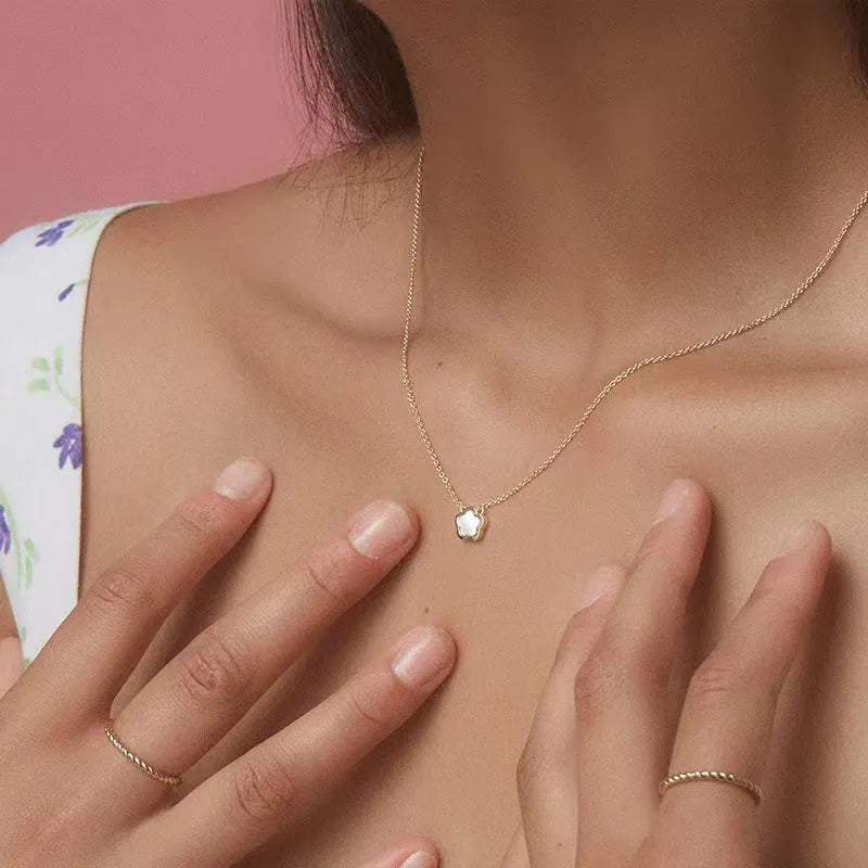 White mother shell flower necklace with floral pendant on gold or silver chain.
