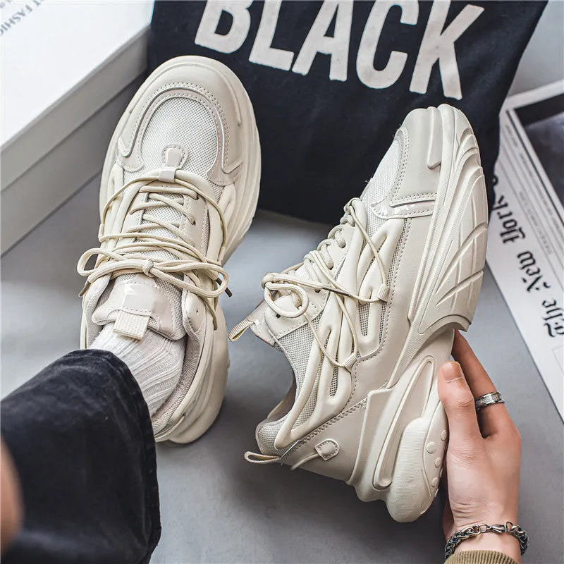 Men's beige and black low-top sneakers with mesh upper and rubber sole, showing lace-up front.
