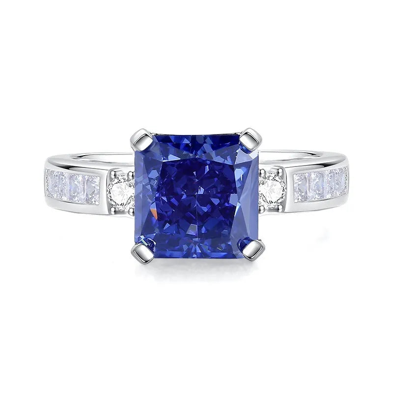 Women's heart-shaped sterling silver ring with ice flower cut coloured zircon stone on finger.