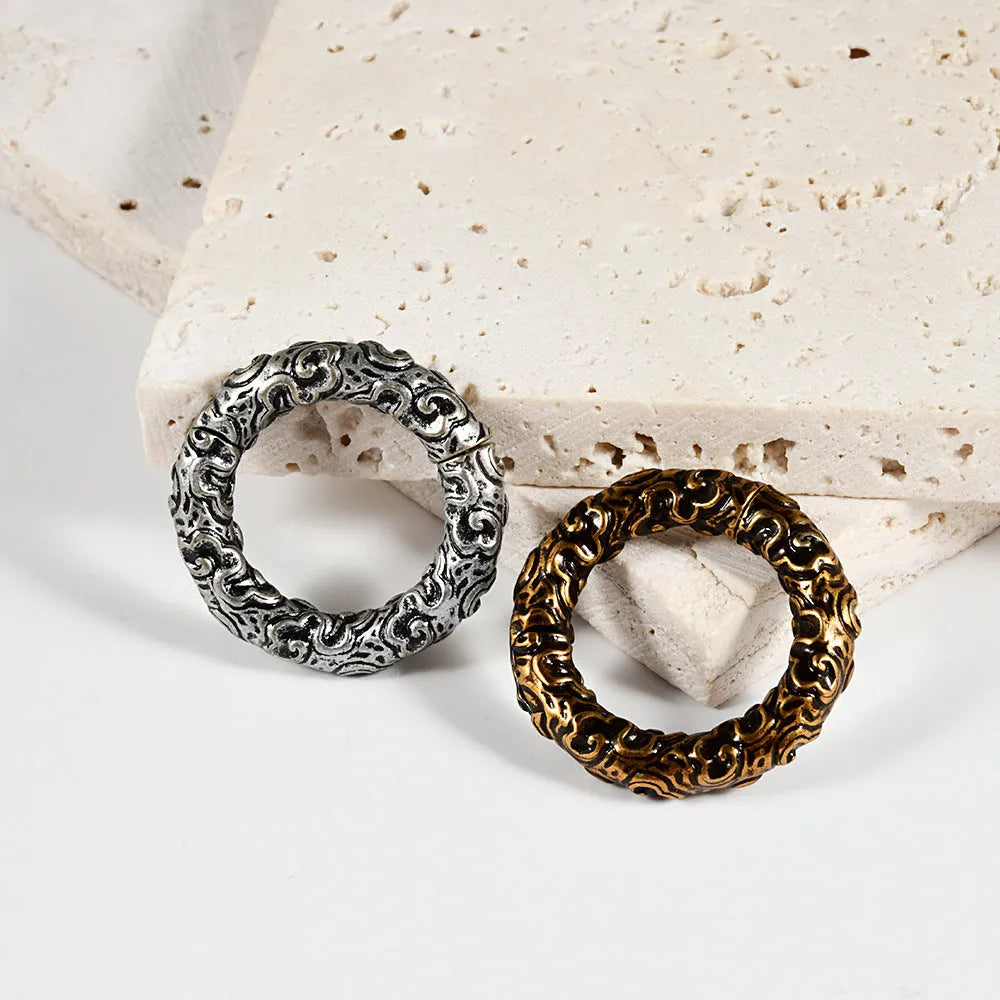 A pair of silver fashion earrings featuring a detailed totem pattern design on a stainless steel base.
