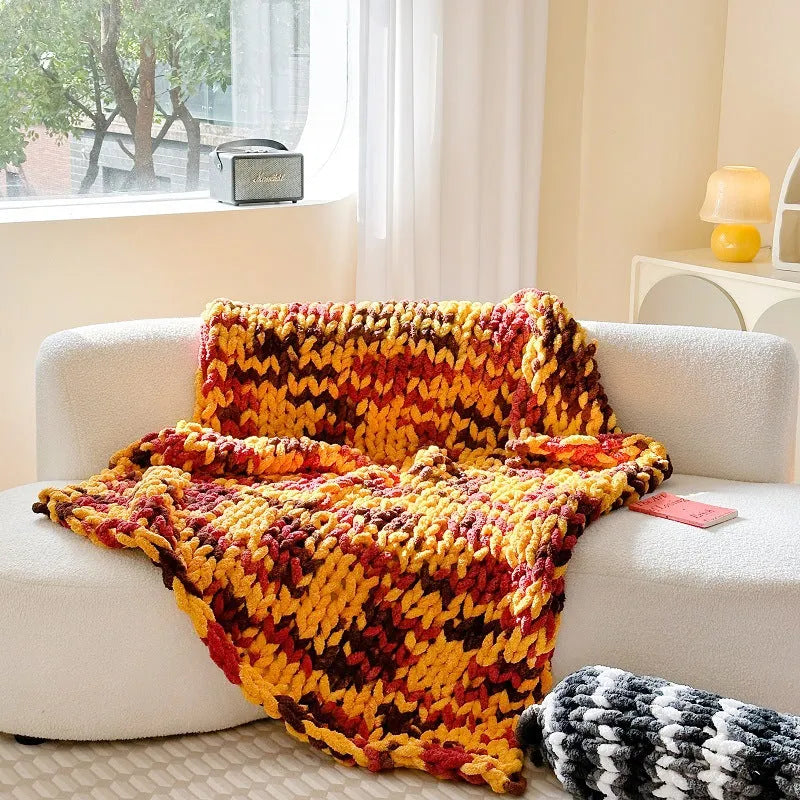 Handmade striped chenille winter blanket in caramel mango colour draped over a bed.