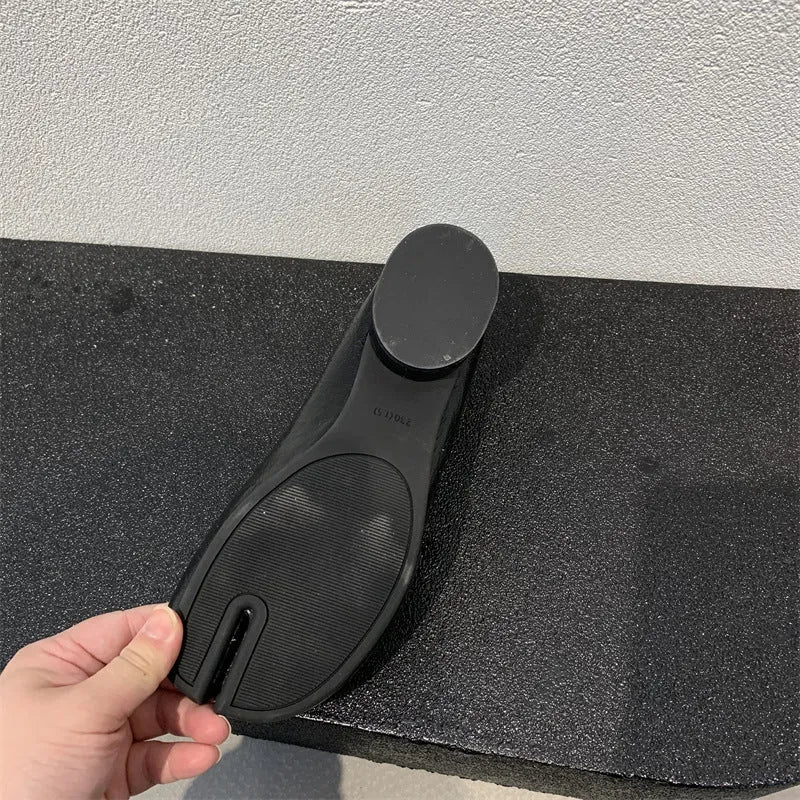 Women's black chunky low heel pumps with round toe and split toe horseshoe design on a rubber sole.