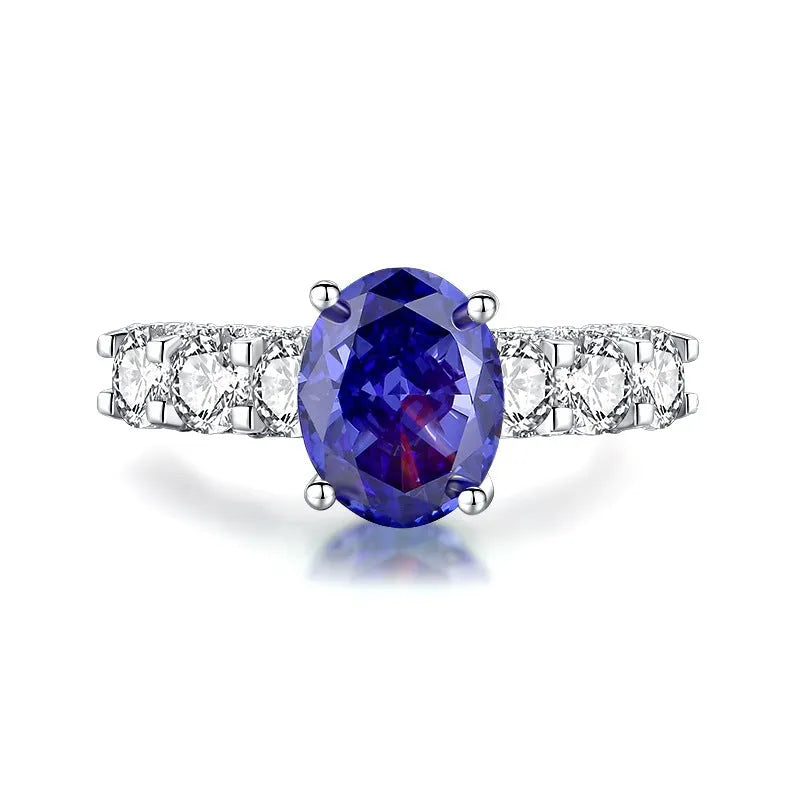 Women's heart-shaped sterling silver ring with ice flower cut coloured zircon stone on finger.
