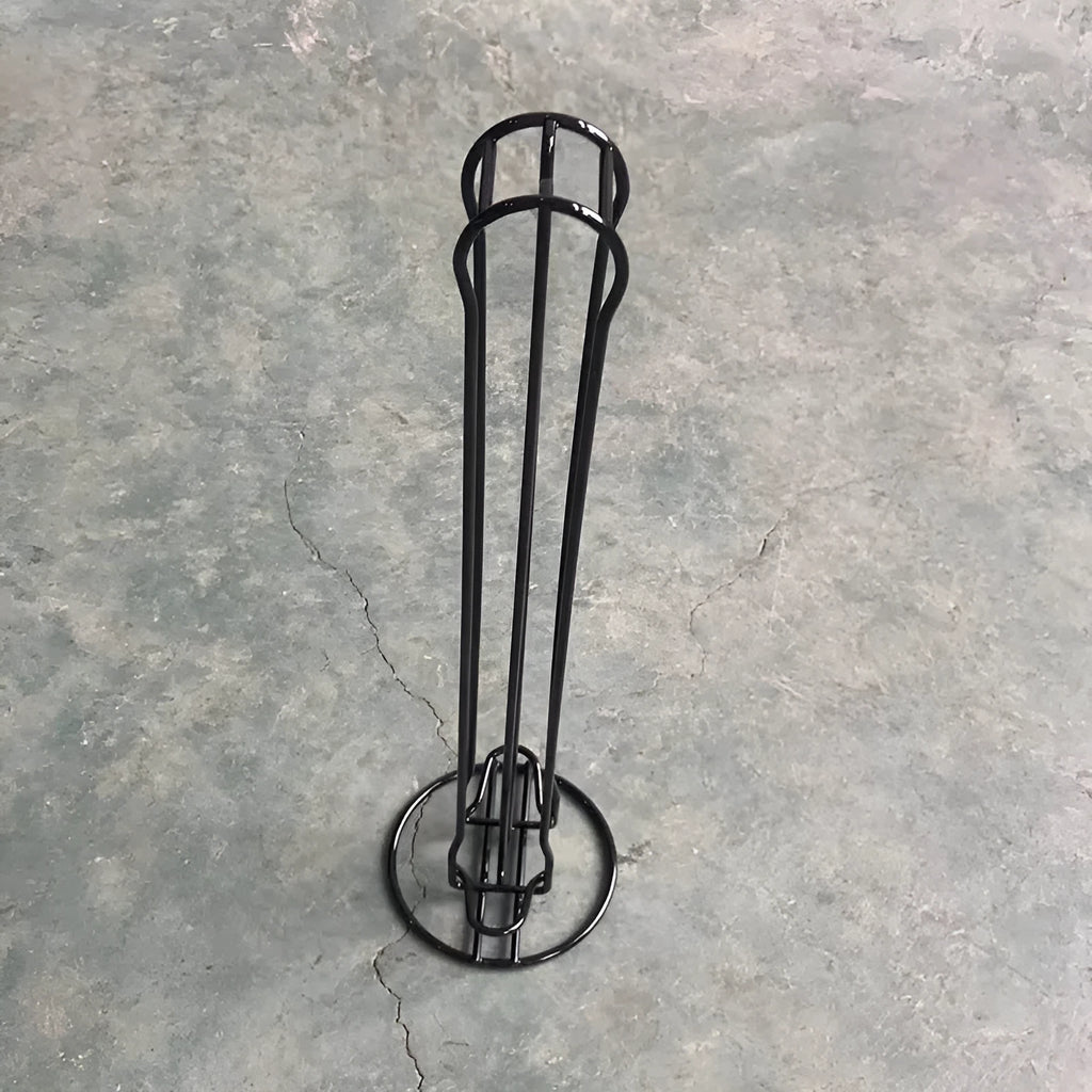 Black wrought iron coffee capsule rack holding 20 pods on display shelves.