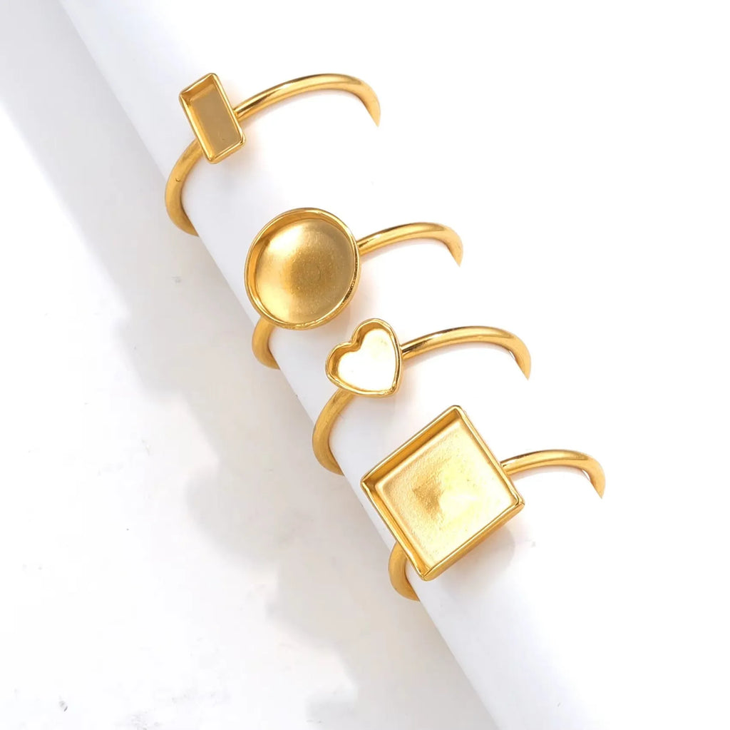 Assortment of golden electroplated stainless steel ring settings and DIY jewellery components in various shapes.