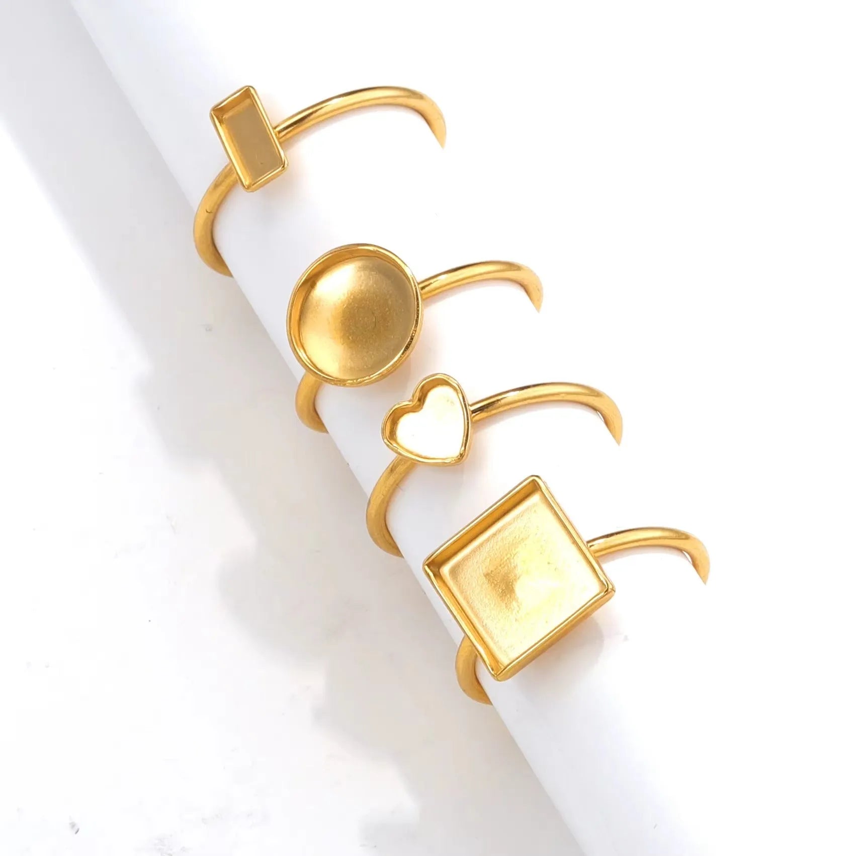 Assortment of golden electroplated stainless steel ring settings and DIY jewellery components in various shapes.