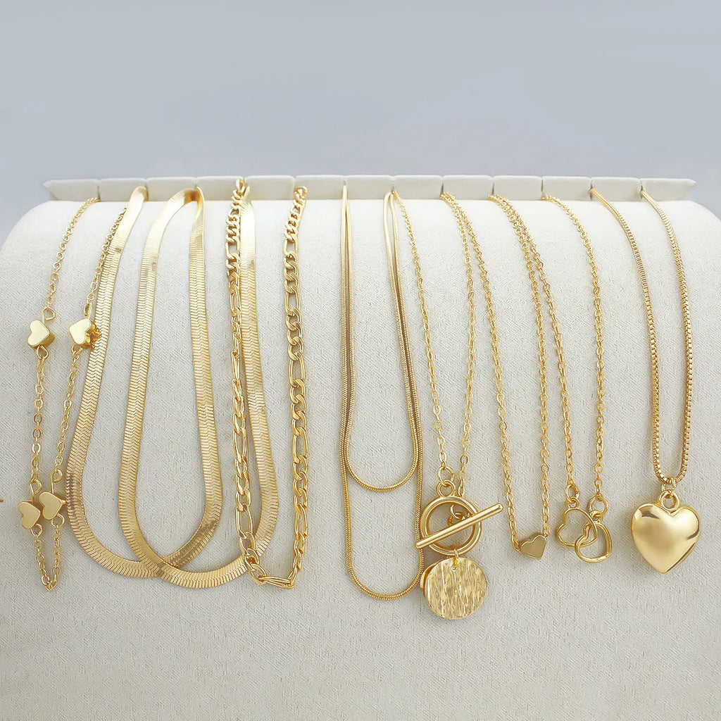Ten gold necklaces with alloy pendants on adjustable snake bone chains in a women's jewellery set