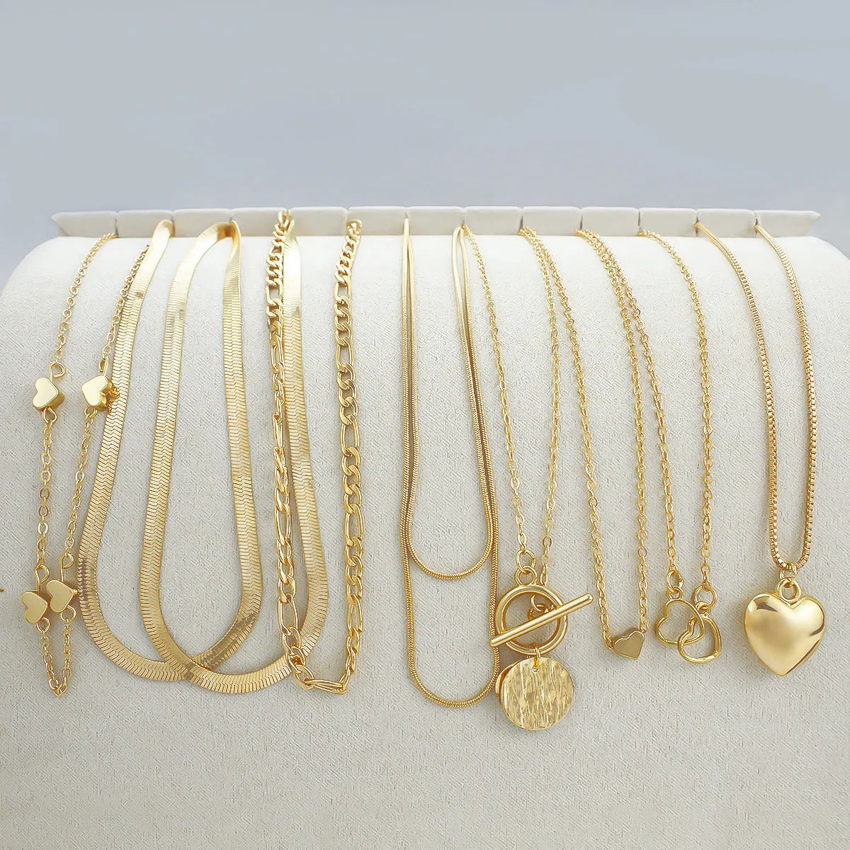 Ten gold necklaces with alloy pendants on adjustable snake bone chains in a women's jewellery set