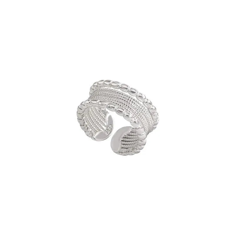 Copper geometric ring with woven twisted layers and adjustable opening.