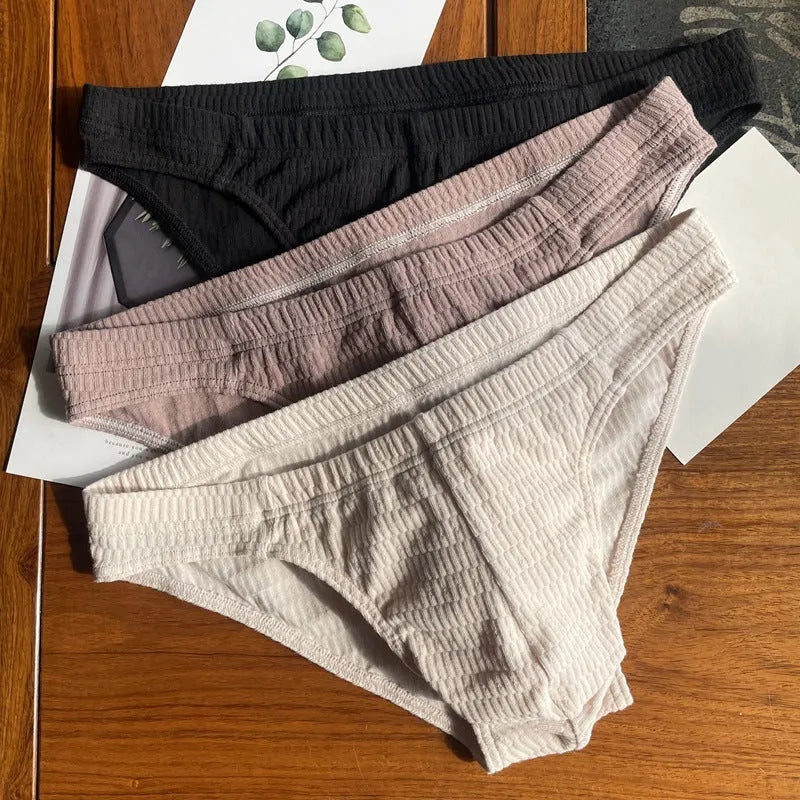 Men's solid colour cotton triangle briefs in mid-waist style, shown in apricot and black colour options.