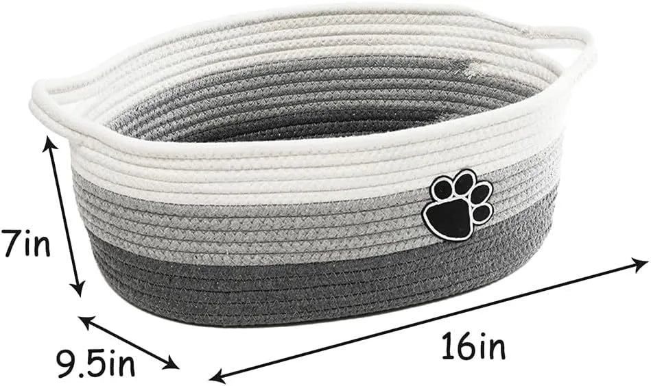 Light beige handmade woven cotton rope storage basket with handle on a wooden surface.