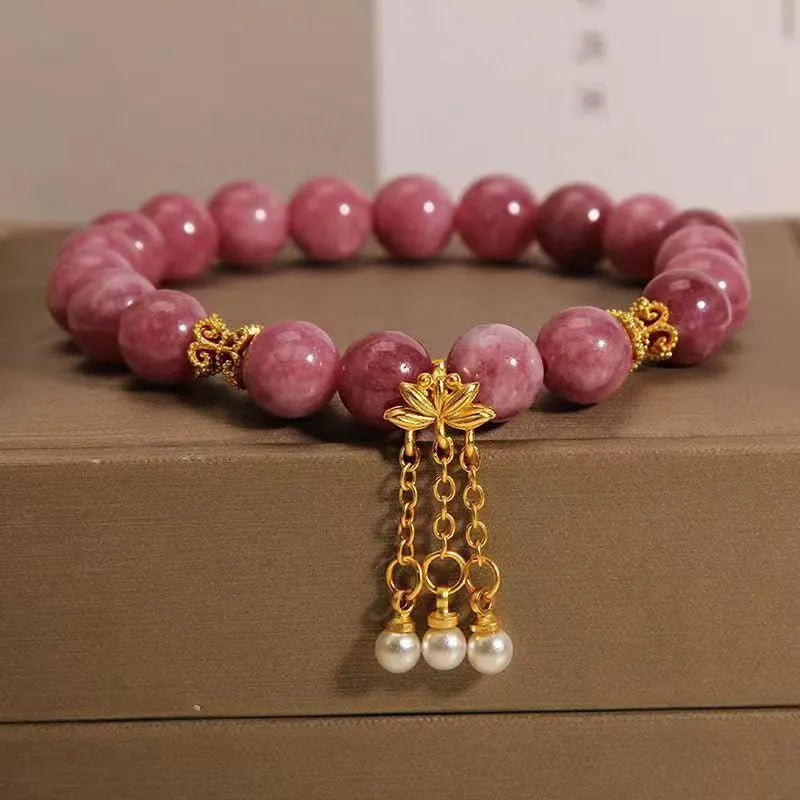 Pink and white natural stone bracelet with lotus flower pendant and tassel.