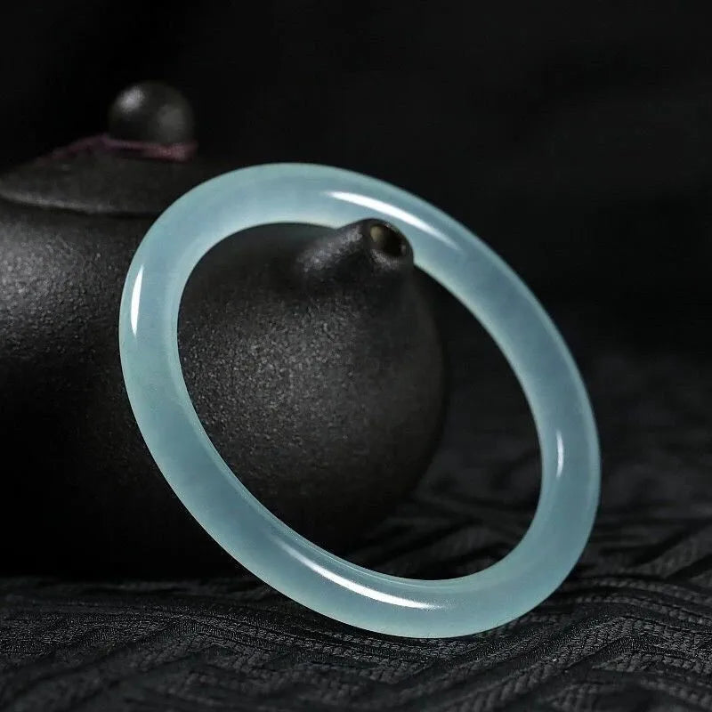 Jade bracelet with floating flower design and auspicious cloud patterns in ice-like emerald finish