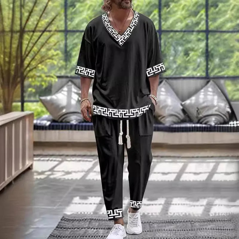 Thin polyester trousers suit with V-neck cropped sleeve jacket and matching trousers on a hanger.