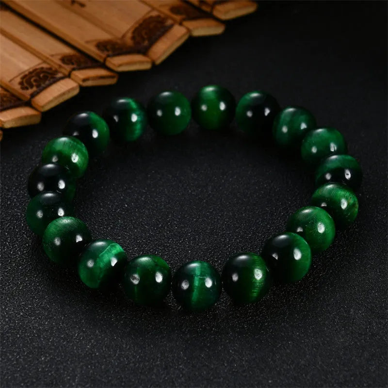 Green Tiger Eye stone beaded bracelet with geometric shaped beads on a wrist.