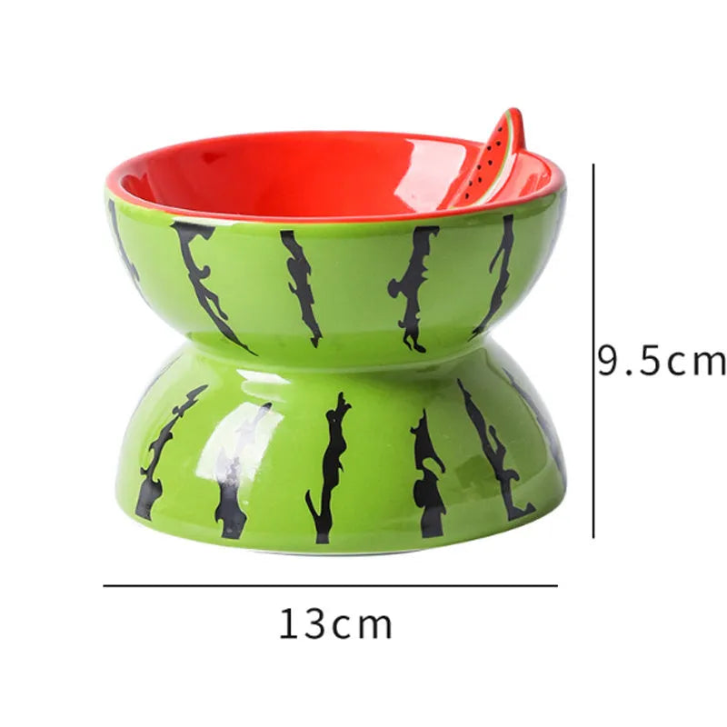 Ceramic raised cat feeder bowl in orange patterned design on a white surface.