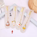 Metal cartoon cat bookmark with food-themed designs including strawberry cake and fruit roll styles