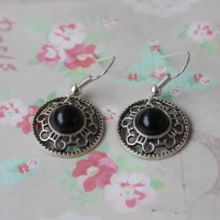 Handmade geometric flower disk earrings in Tibetan silver and turquoise with auspicious cloud patterns.