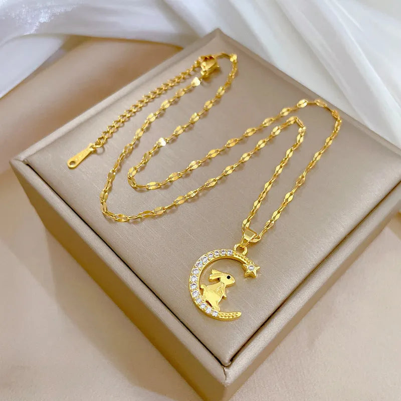 Gold colour copper rabbit and crescent moon full diamond necklace with micro inlay setting on studio background