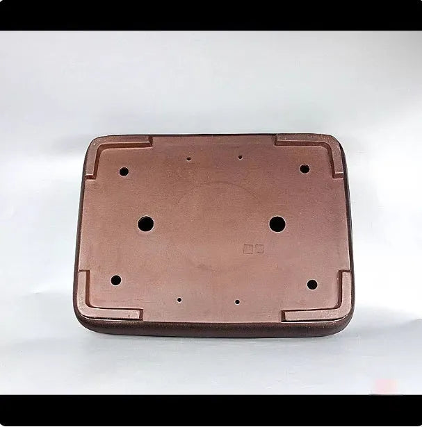 Handmade rectangular purple clay flower pot for indoor plants on a table.