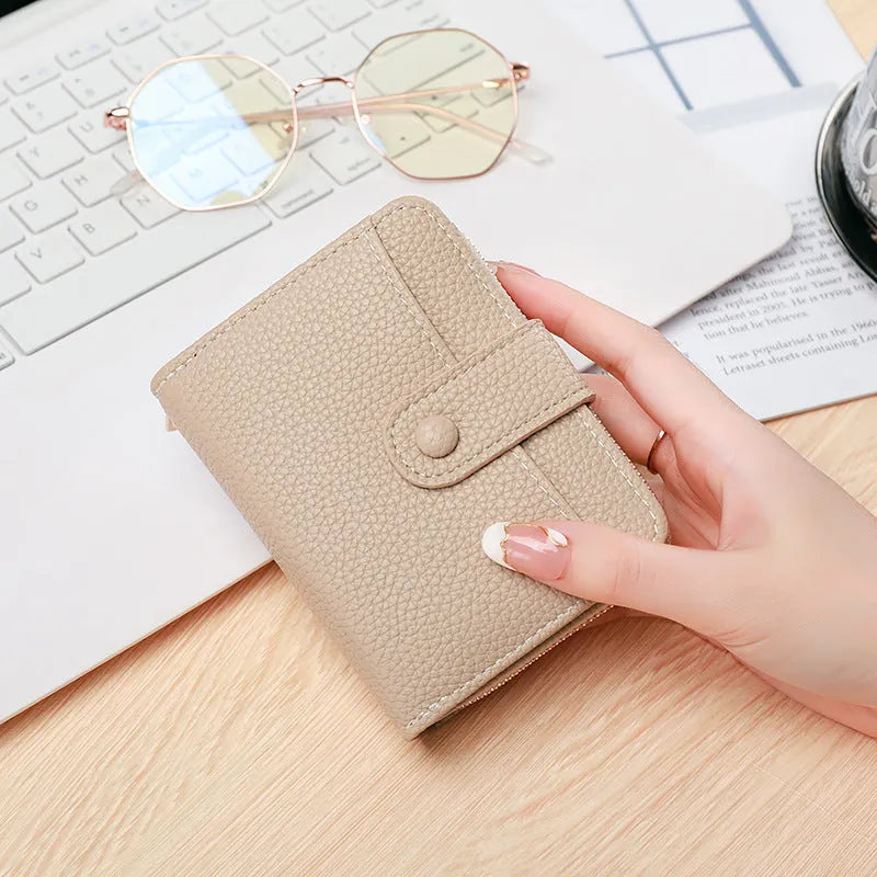 Ladies short pu leather wallet with lychee pattern in beige, showing two-fold design with card slots.