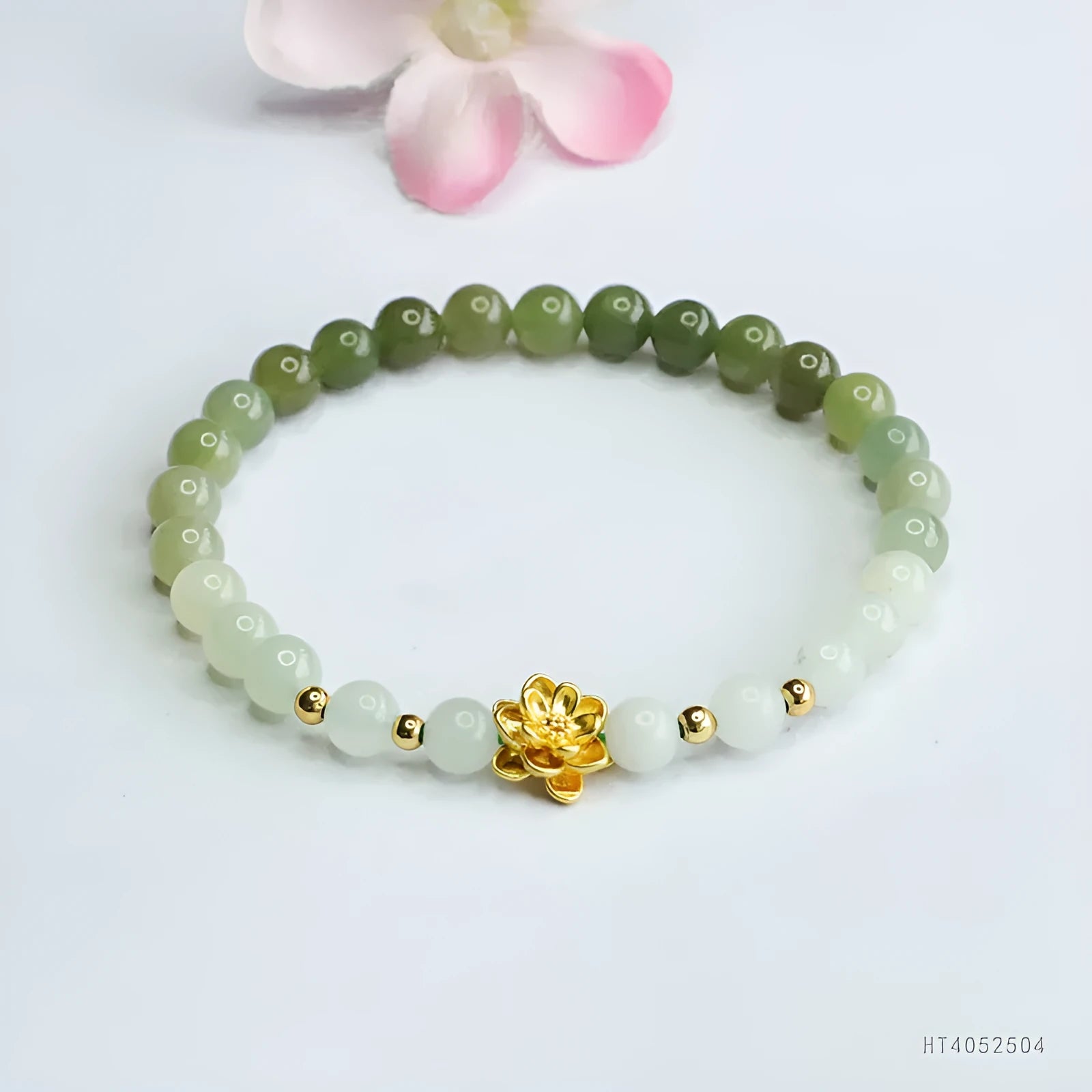Hand-woven clear water gradient Hetian jade bracelet with flower-shaped beads on a white background.