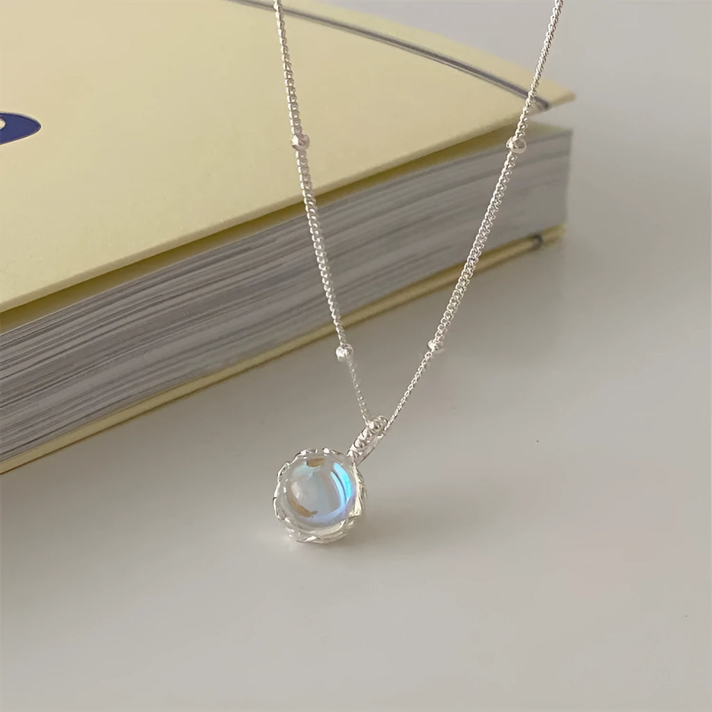 Polished sterling silver necklace for women with round geometric stone pendant on curb chain.