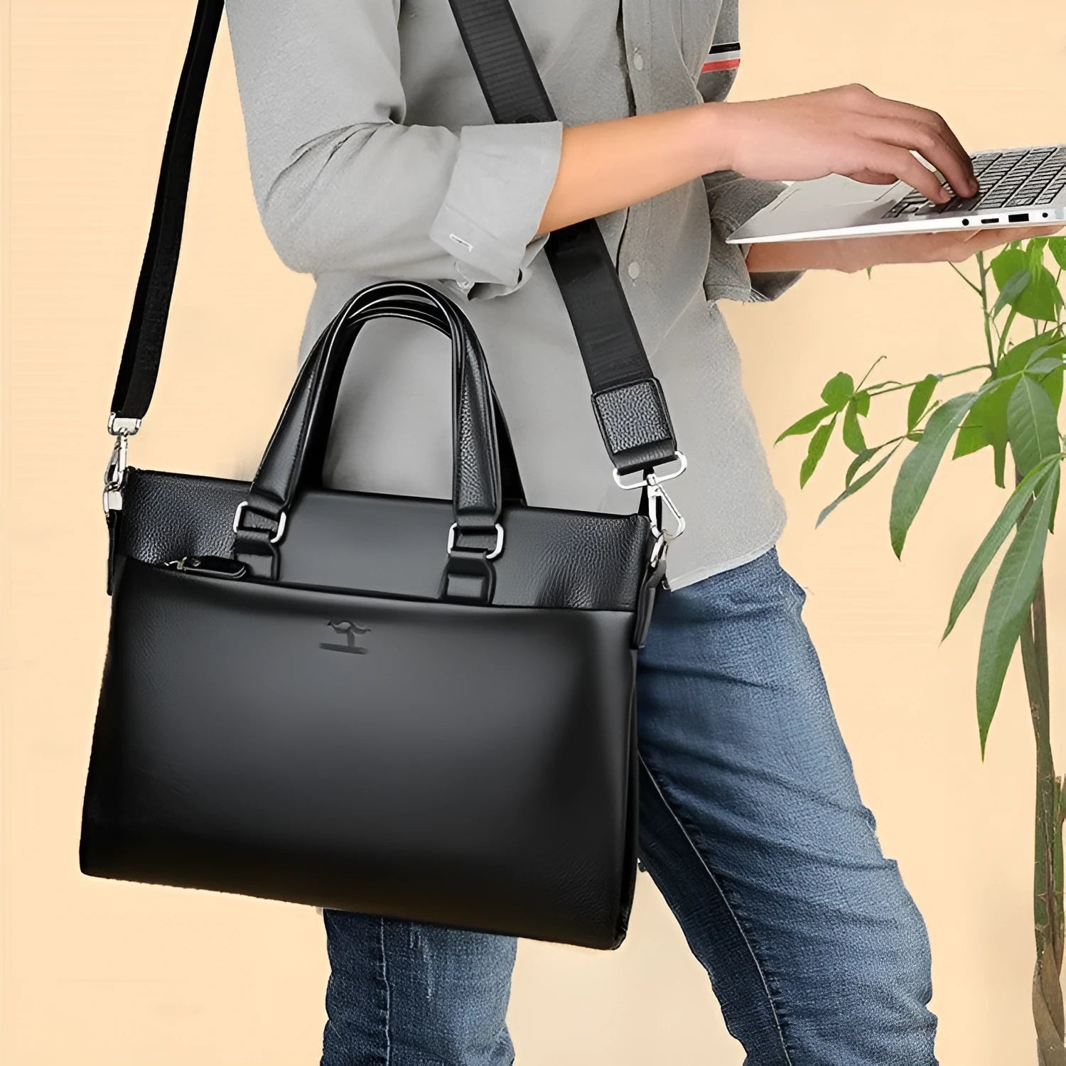 Men's black and brown PU leather business messenger bag with splicing design on a table.