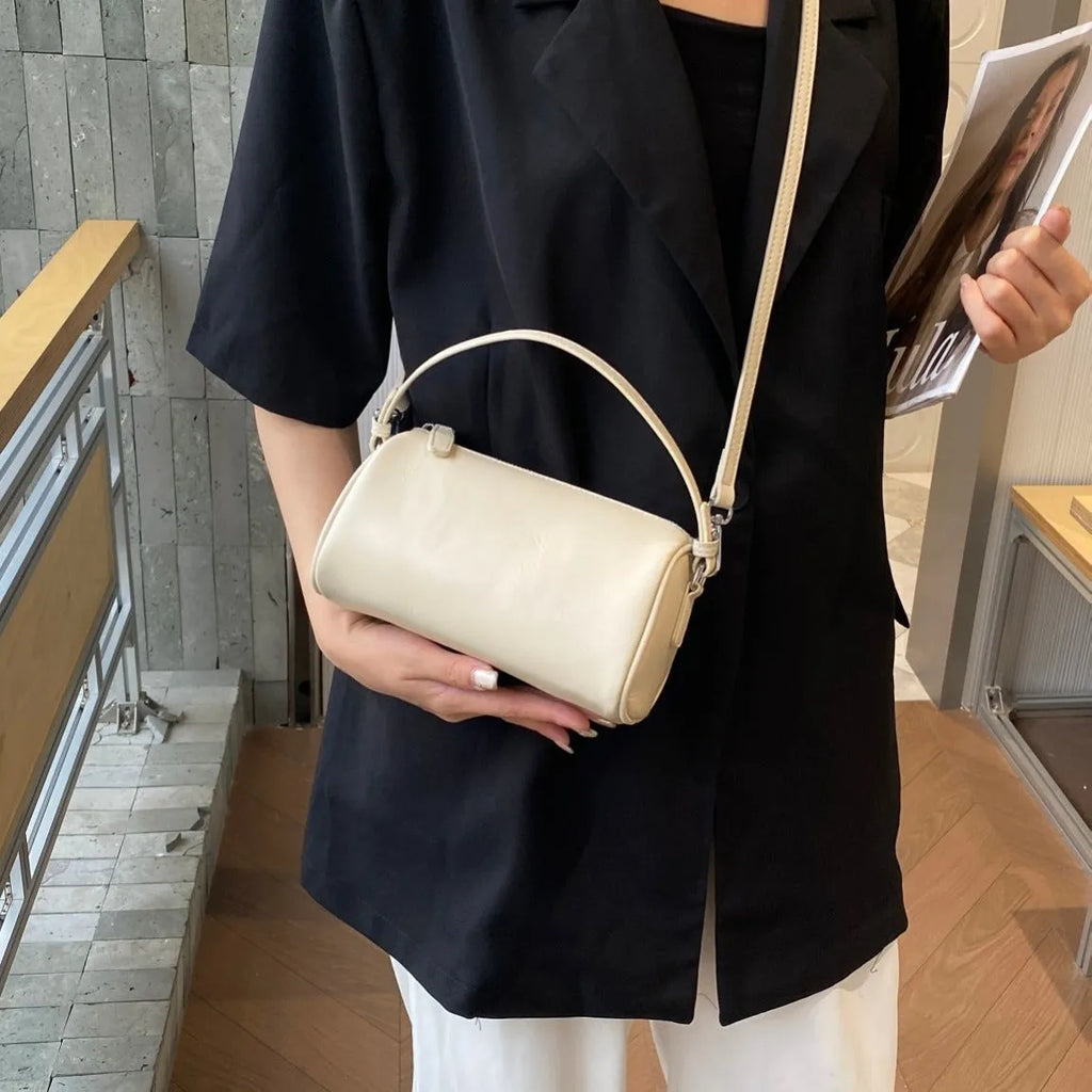 A soft genuine leather cylindrical crossbody bag for mobile phones in street style.