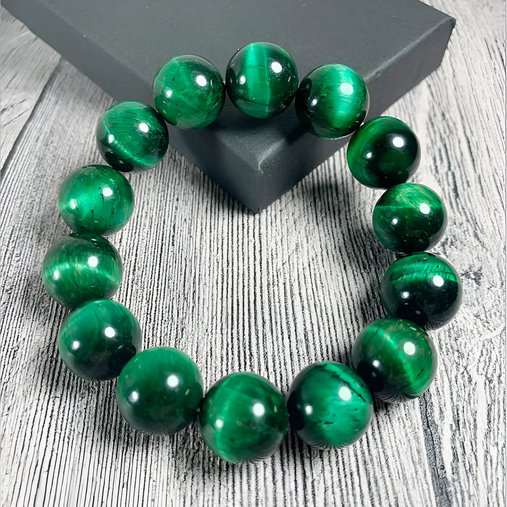 Green Tiger Eye stone beaded bracelet with geometric shaped beads on a wrist.