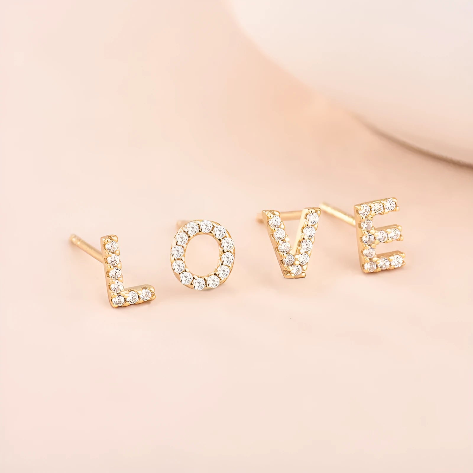 Brass gold plated alphabet earrings showing zircon letter detailing on copper base with gold plating