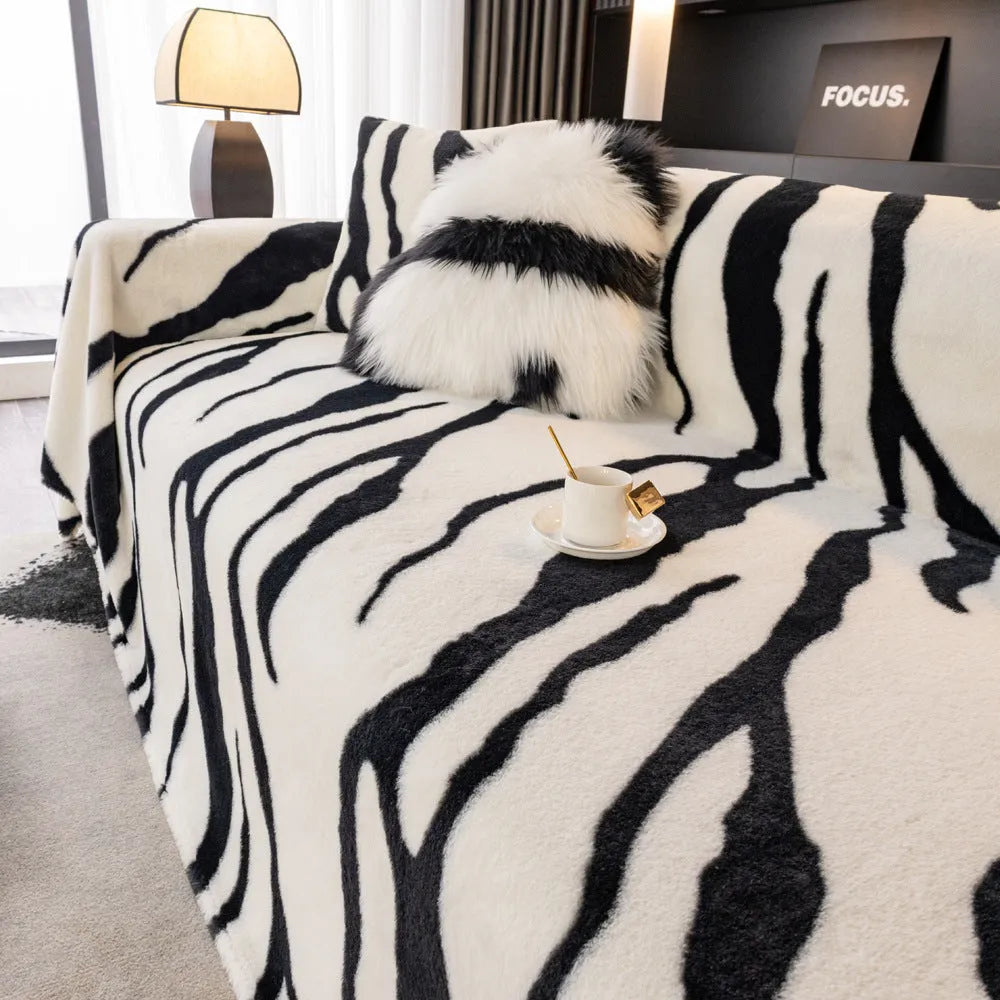 Zebra pattern flannel sofa slipcover in caramel colour, shown draped over a sofa with matching square pillow.